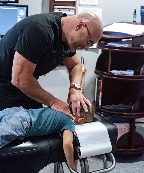 Chiropractor Naperville IL Timothy Erickson Adjusting Boy